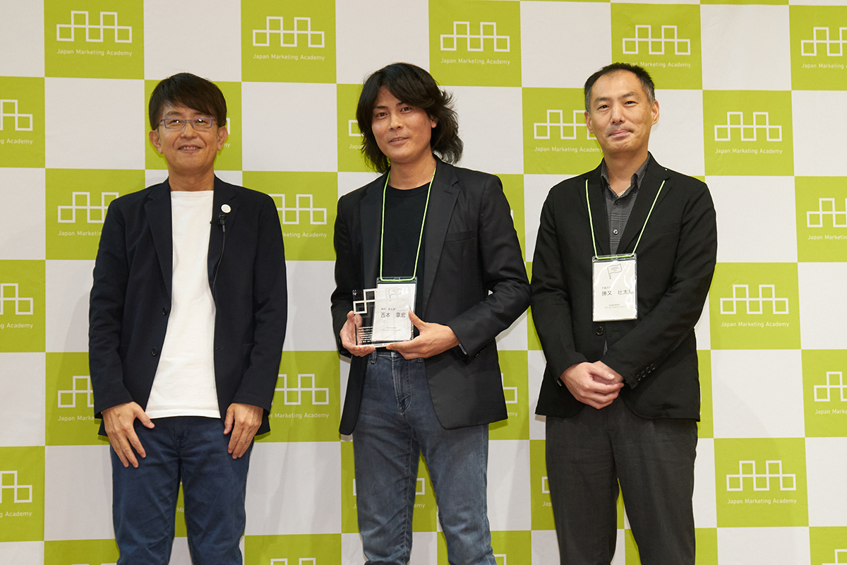 写真中央が西本氏、右側は共同研究者の勝又氏、左側は学会長の西川氏